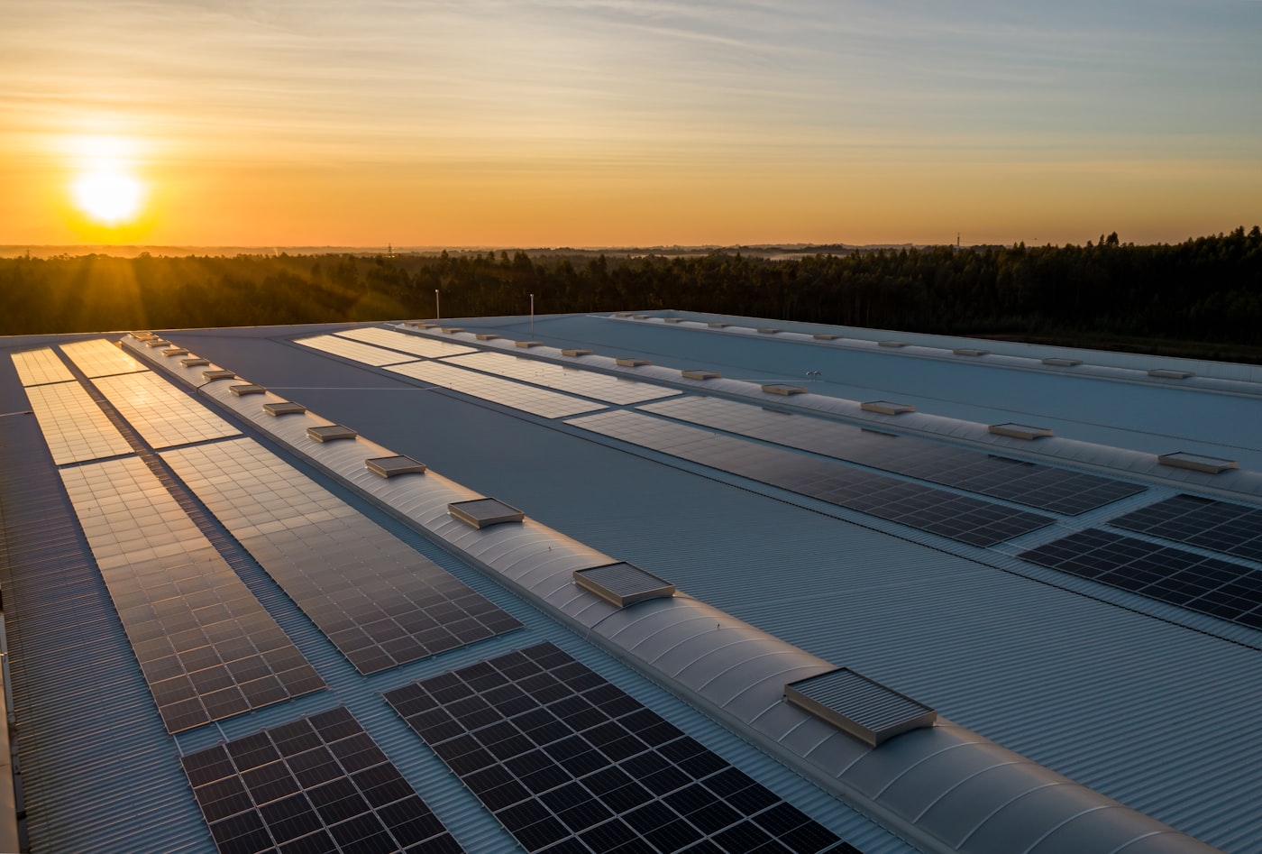 Instalación solar sobre cubierta industrial al atardecer
